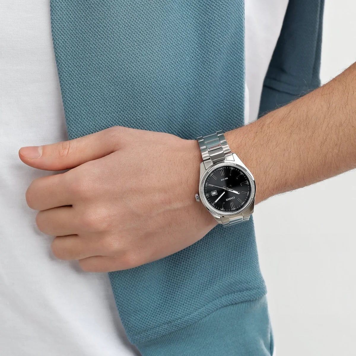 Casio MTP-1302D-1A1 — Black dial watch worn with a blue shirt