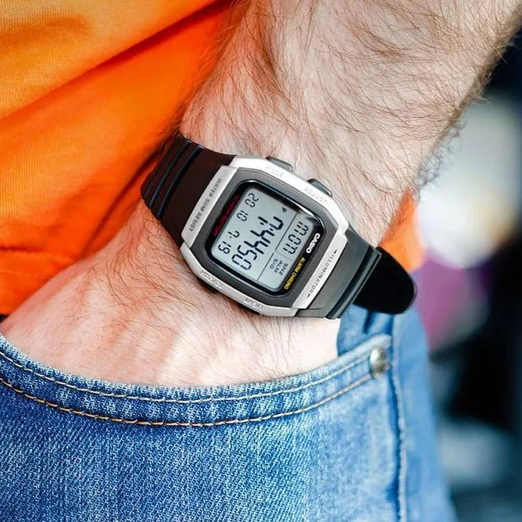 Casio W-96H-1A — watch worn beside jeans and an orange shirt.
